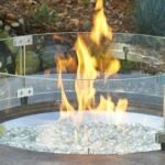 Round Fire Pit Wind Guard on a lit fire pit with Clear Fire Glass