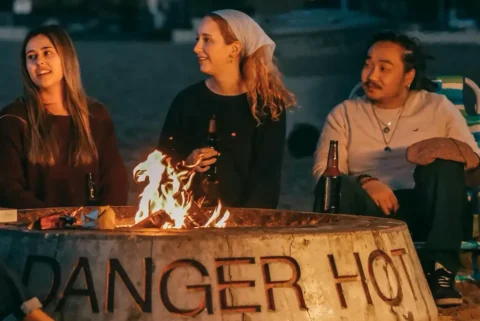 Group of young people sitting around a fire pit