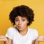 A young lady holding her palms up with a quizzical look on her face as if to ask - How much Fire Glass do i need?