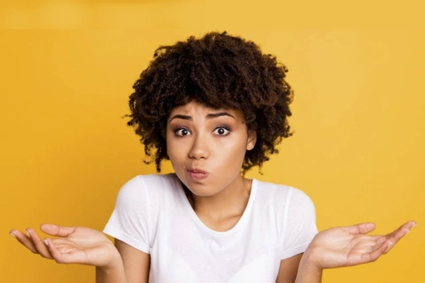 A young lady holding her palms up with a quizzical look on her face as if to ask - How much Fire Glass do i need?