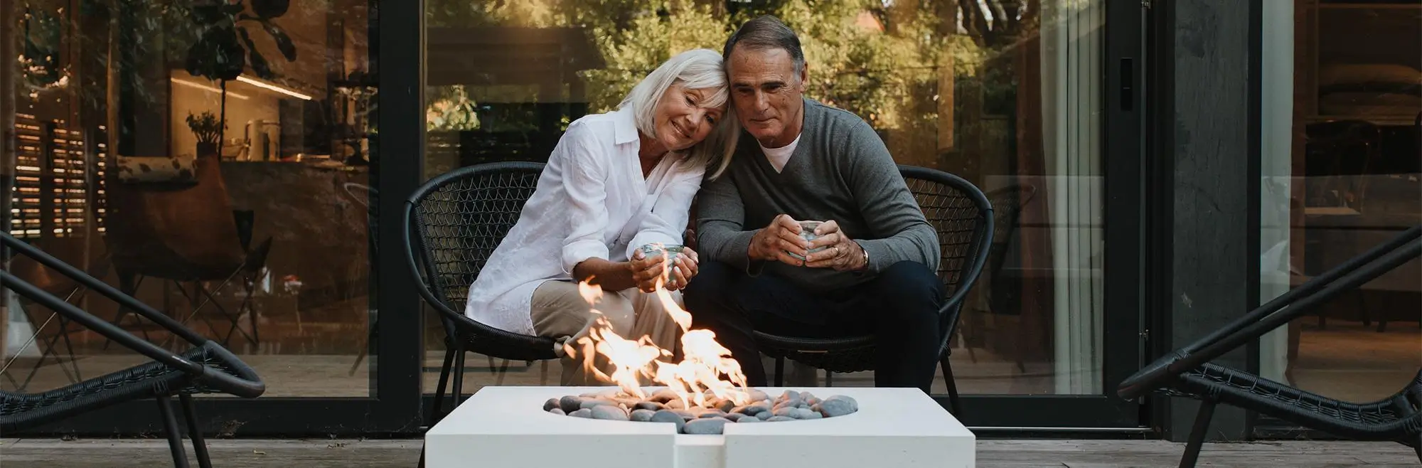 Bravo Gas Fire Pit with a couple relaxing on the terrace