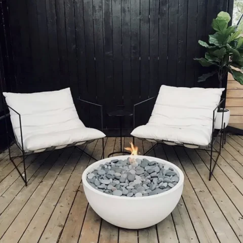 Serenade Fire Pit 32 Inch with Slate Beachstones on a backyard deck with seating for two