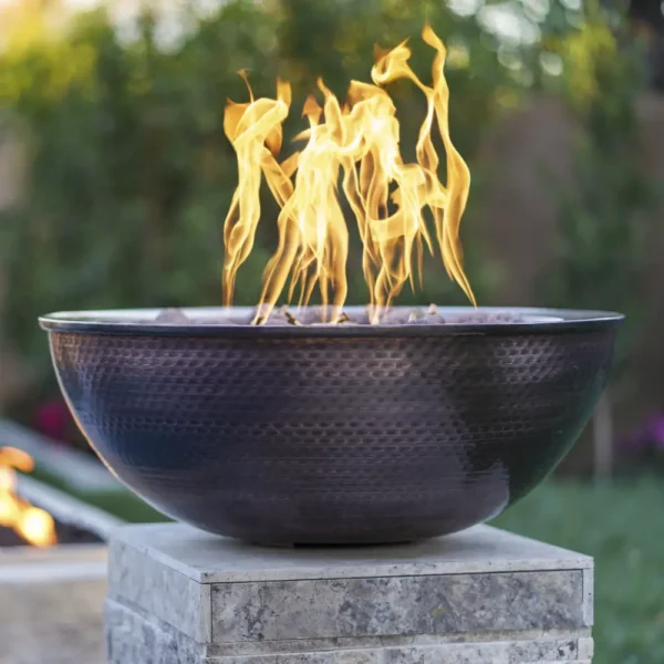 Sedona Copper Fire Bowl on a pedestal in a garden
