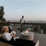 lightweight concrete belmont fire pit on a deck overlooking the city in a social setting