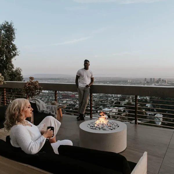 lightweight concrete belmont fire pit on a deck overlooking the city in a social setting